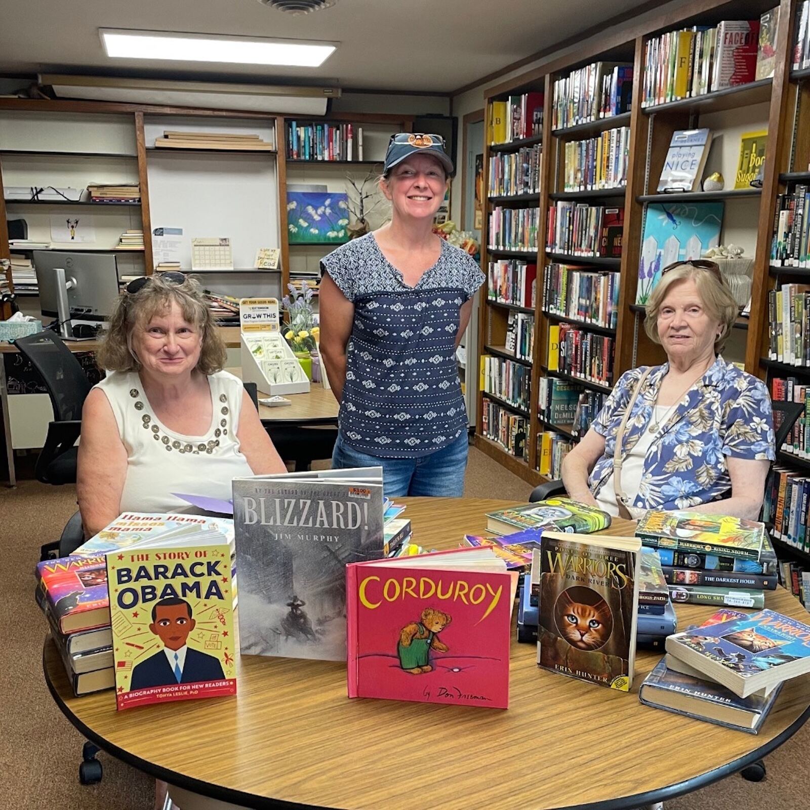 Members with a table of donated children's books for rural libraries