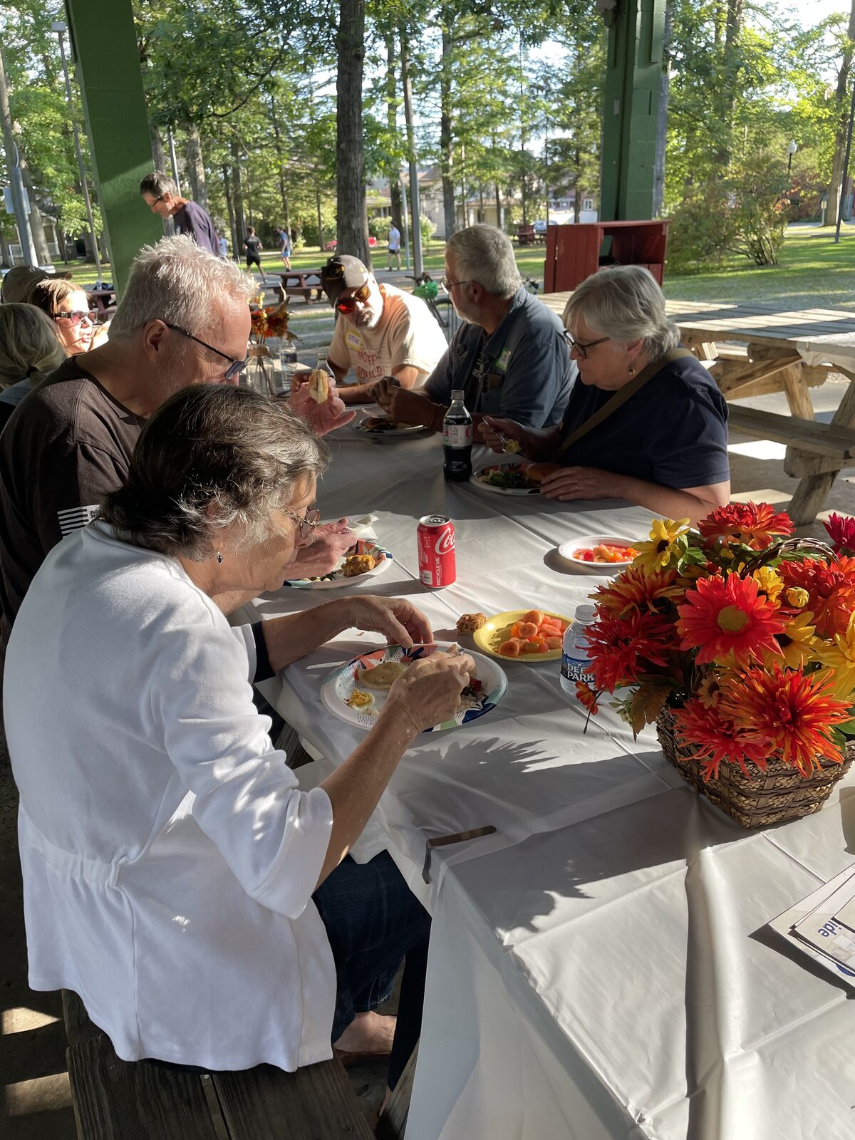 Guests seated at a table of desserts and autumn flowers at the Dessert Auction