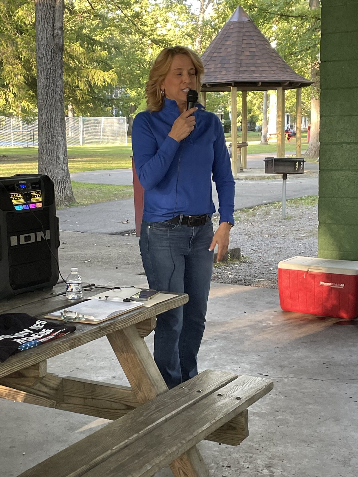An auctioneer with a microphone at the park pavilion