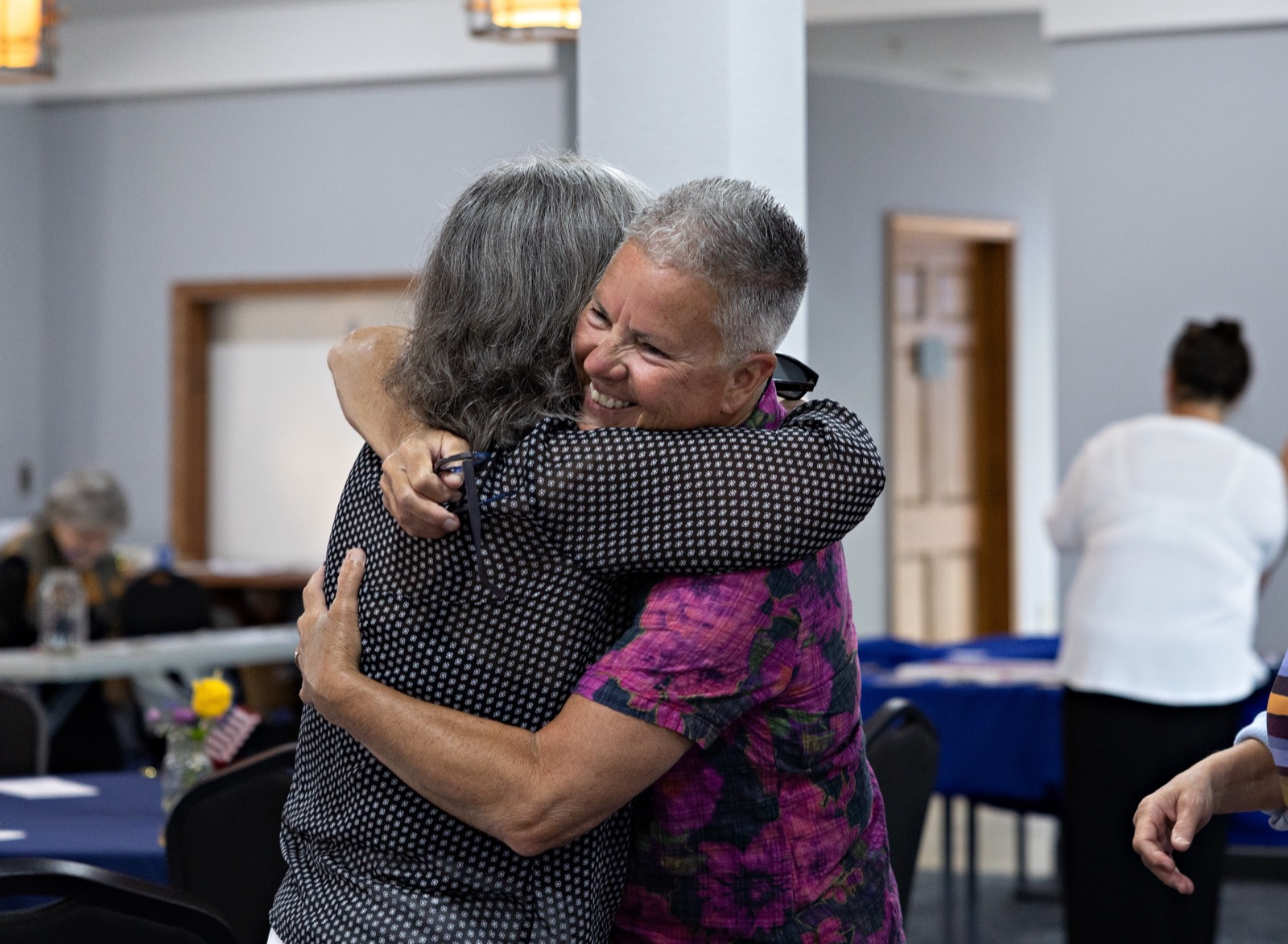 Two attendees share a hug at the Democracy Dinner